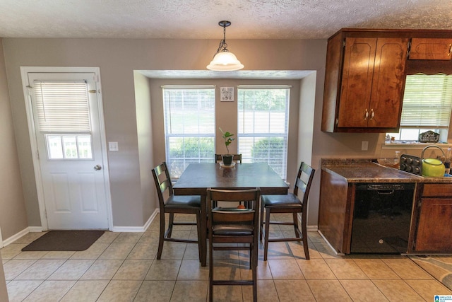 dining area featuring a textured ceiling and light tile patterned floors