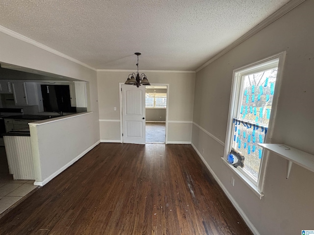 unfurnished dining area with ornamental molding, dark hardwood / wood-style floors, and an inviting chandelier