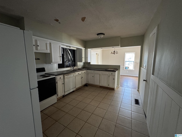 kitchen with light tile patterned flooring, white appliances, a textured ceiling, and white cabinets