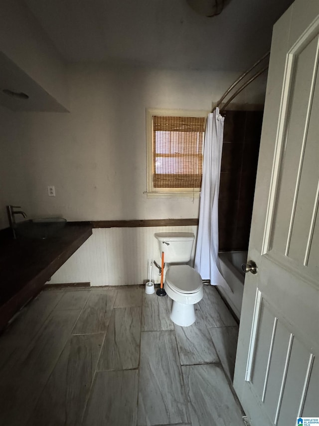 bathroom featuring shower / bath combination with curtain and toilet