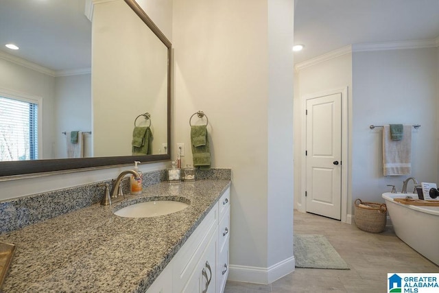 bathroom featuring vanity, wood-type flooring, ornamental molding, and a bathing tub