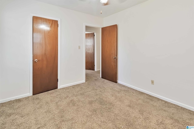 unfurnished bedroom featuring light colored carpet and ceiling fan