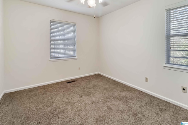 empty room with ceiling fan, a healthy amount of sunlight, and carpet floors