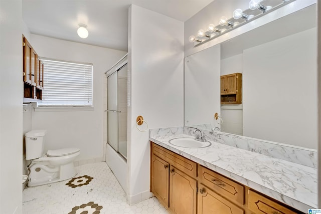 full bathroom featuring vanity, bath / shower combo with glass door, and toilet