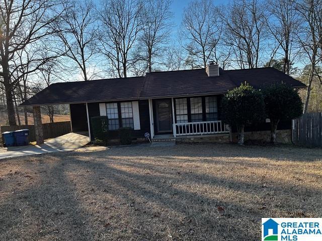 ranch-style house with a front yard, a carport, and a porch