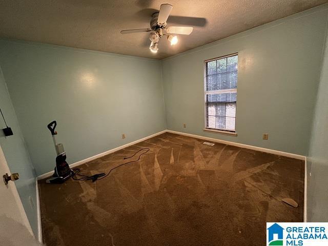 empty room featuring crown molding, ceiling fan, carpet, and a textured ceiling