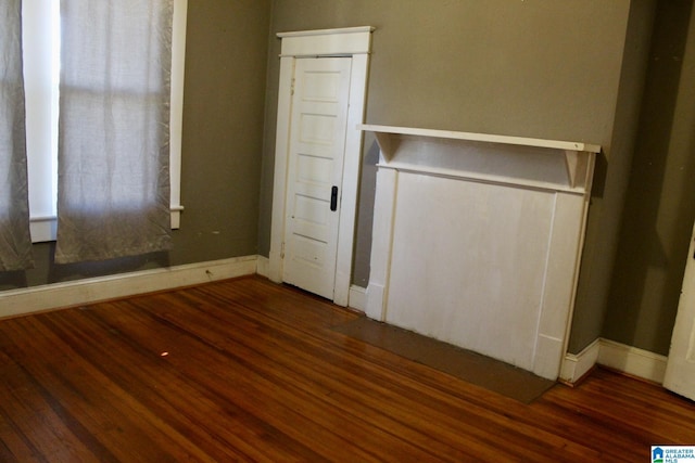 unfurnished bedroom featuring wood finished floors and baseboards