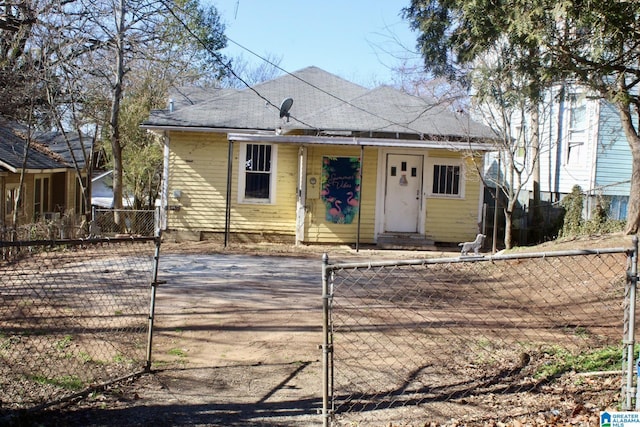 bungalow-style home with a fenced front yard, entry steps, and a gate