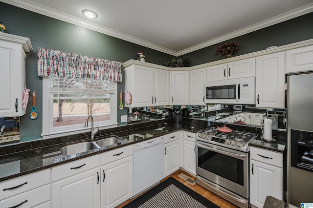 kitchen featuring white cabinetry, stainless steel appliances, sink, and dark stone counters