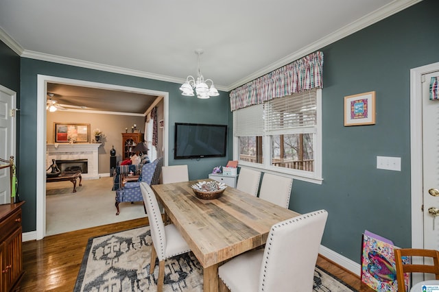 dining room with crown molding, dark hardwood / wood-style flooring, and ceiling fan with notable chandelier