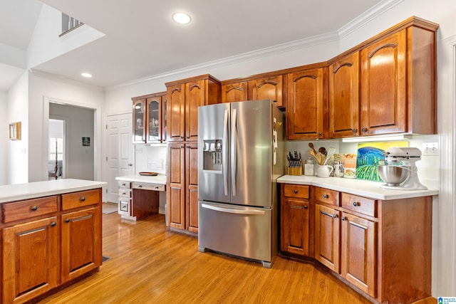 kitchen featuring crown molding, stainless steel fridge, and light wood-type flooring