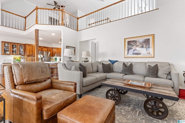 living room featuring ceiling fan and a high ceiling