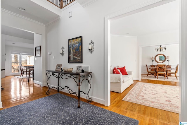 hall with ornamental molding, a chandelier, and hardwood / wood-style floors