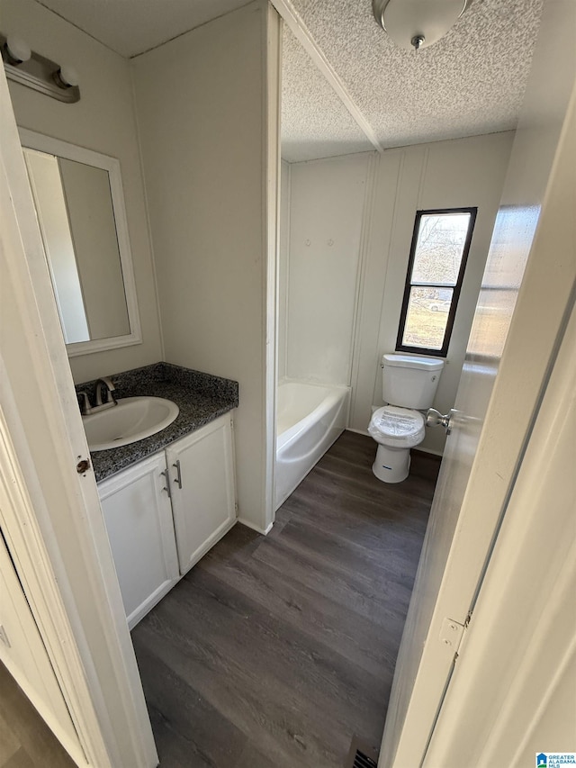 bathroom with wood-type flooring, toilet, a textured ceiling, and vanity