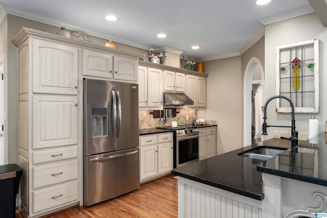 kitchen featuring stainless steel appliances, sink, hardwood / wood-style floors, and kitchen peninsula