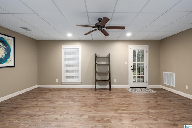 empty room featuring ceiling fan, a paneled ceiling, and light wood-type flooring