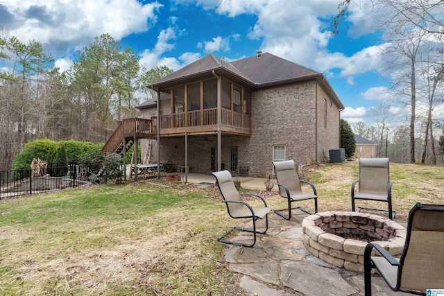 rear view of house featuring a lawn, central AC, a patio, an outdoor fire pit, and a sunroom