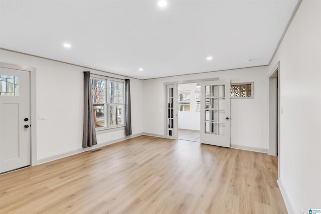 entrance foyer featuring french doors, ornamental molding, and light hardwood / wood-style flooring