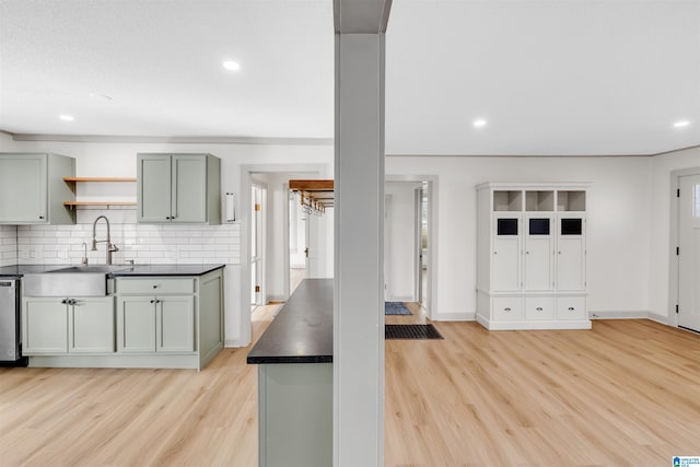 kitchen featuring sink, stainless steel dishwasher, decorative backsplash, and light hardwood / wood-style flooring