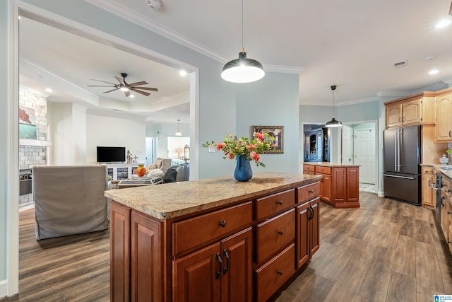 kitchen featuring pendant lighting, high end refrigerator, dark wood-type flooring, and a kitchen island