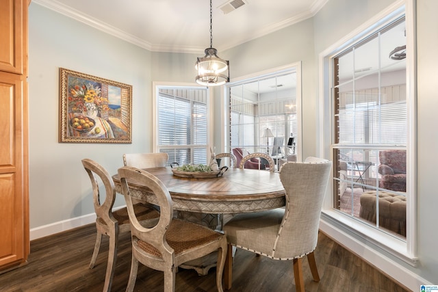 dining room with crown molding, dark hardwood / wood-style flooring, and a chandelier