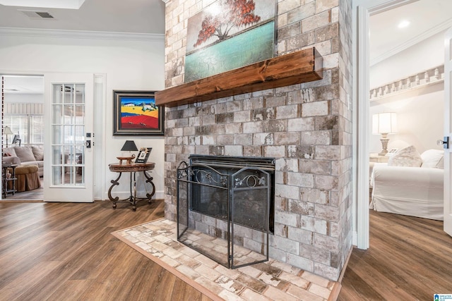 details featuring crown molding, a brick fireplace, and hardwood / wood-style floors