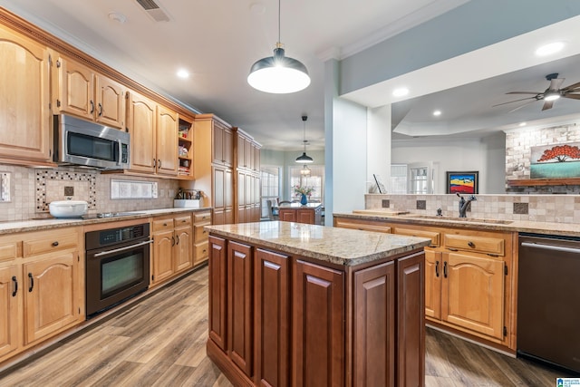 kitchen with sink, crown molding, decorative light fixtures, a center island, and appliances with stainless steel finishes