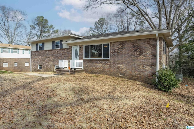 split level home featuring brick siding and crawl space