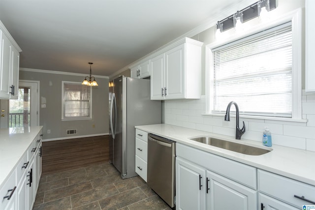 kitchen with visible vents, ornamental molding, a sink, white cabinets, and appliances with stainless steel finishes