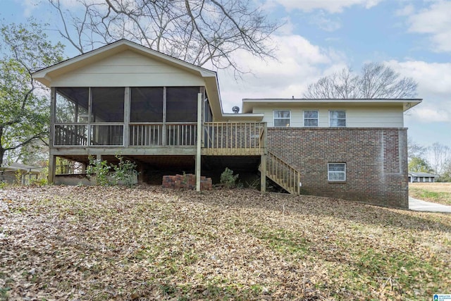 back of property with brick siding, stairs, and a sunroom