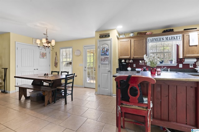 kitchen with an inviting chandelier, light tile patterned floors, and decorative light fixtures