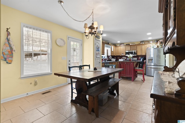 tiled dining area with an inviting chandelier