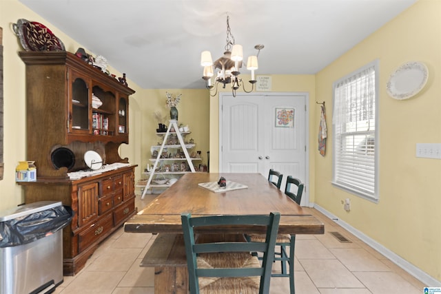 tiled dining space with a chandelier