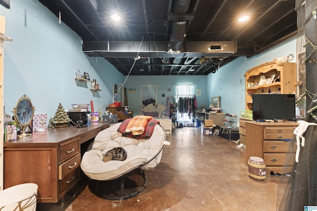 home office with built in desk and concrete flooring