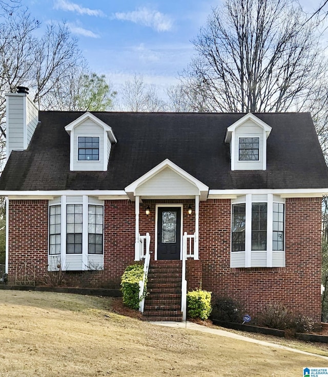 cape cod-style house with a front lawn