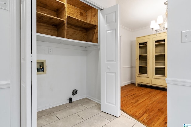 washroom featuring hookup for a washing machine, light tile patterned flooring, a notable chandelier, and crown molding