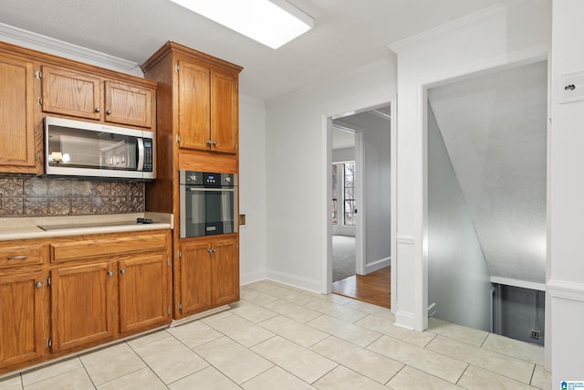 kitchen featuring ornamental molding, appliances with stainless steel finishes, light tile patterned floors, and backsplash