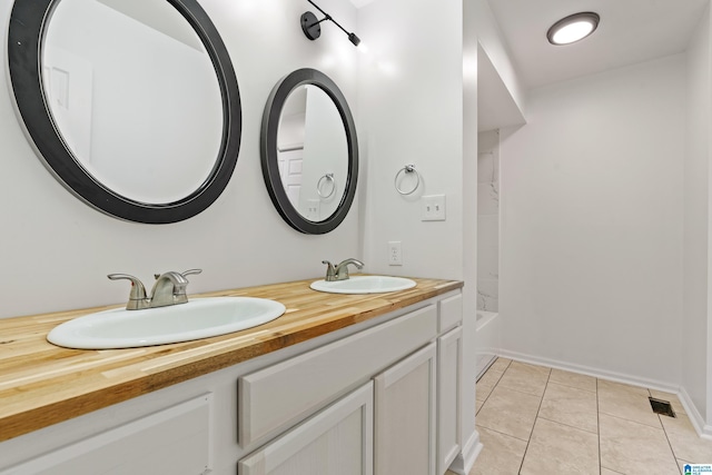 bathroom with tile patterned floors, bathing tub / shower combination, and vanity