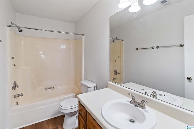 full bathroom featuring hardwood / wood-style flooring, vanity, bathtub / shower combination, and toilet