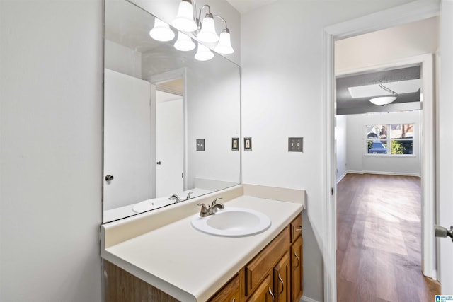 bathroom with hardwood / wood-style flooring, vanity, and a chandelier