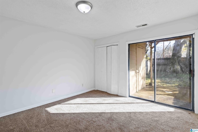 carpeted spare room with a textured ceiling