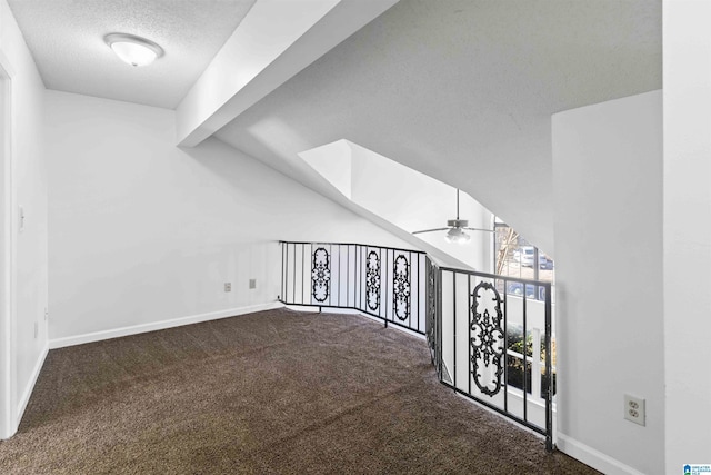 interior space featuring a textured ceiling, carpet, and vaulted ceiling with beams