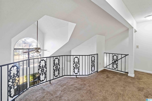 corridor featuring lofted ceiling, a healthy amount of sunlight, and carpet