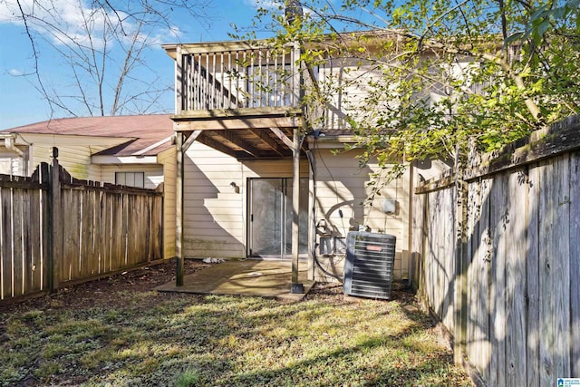 rear view of property with cooling unit and a yard