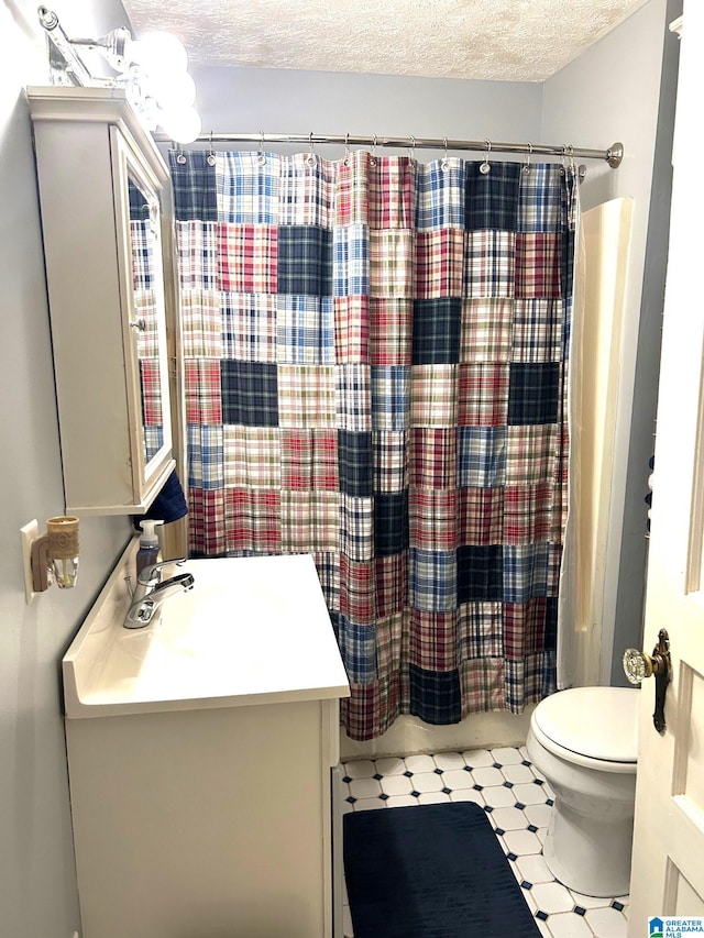 full bathroom featuring shower / bath combo, vanity, a textured ceiling, and toilet