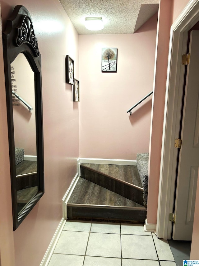 staircase featuring tile patterned floors and a textured ceiling