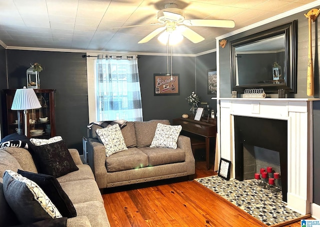 living room with crown molding, ceiling fan, and wood-type flooring