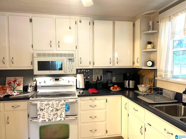 kitchen with white cabinetry, sink, and white appliances