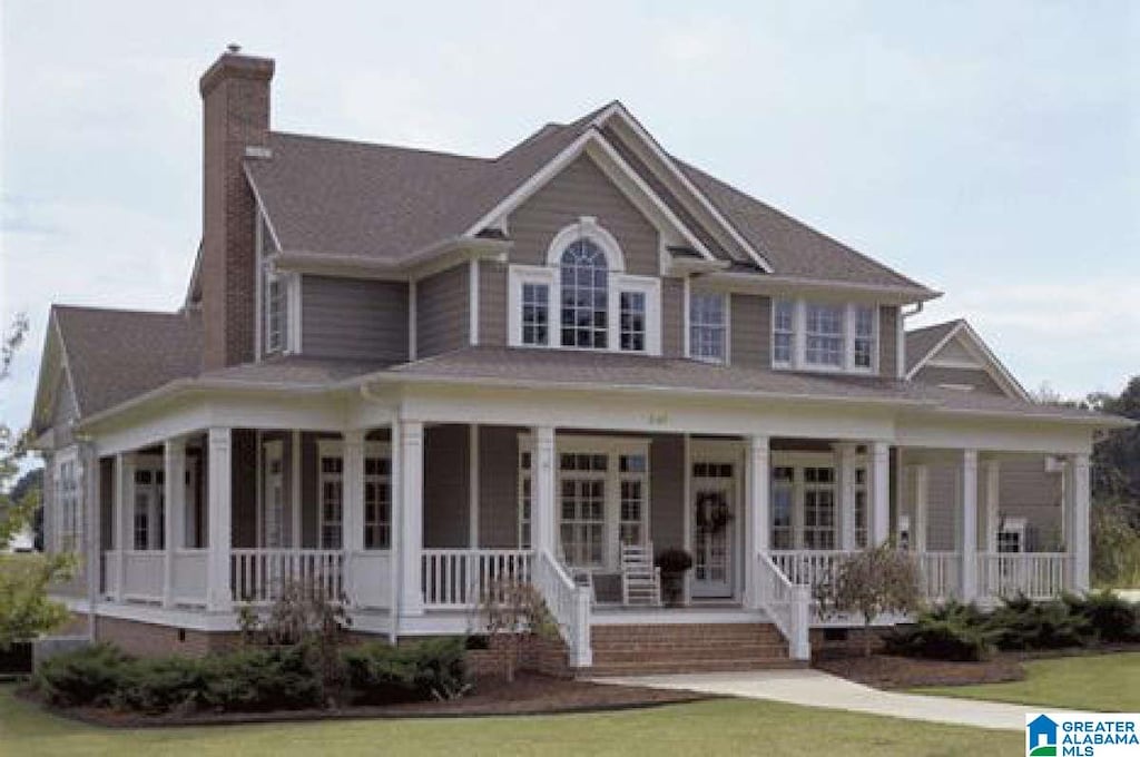 farmhouse-style home with covered porch and a front lawn