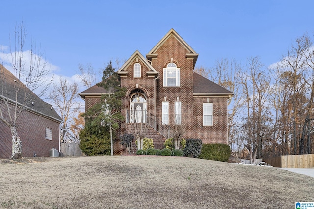 front facade featuring a front lawn and central air condition unit